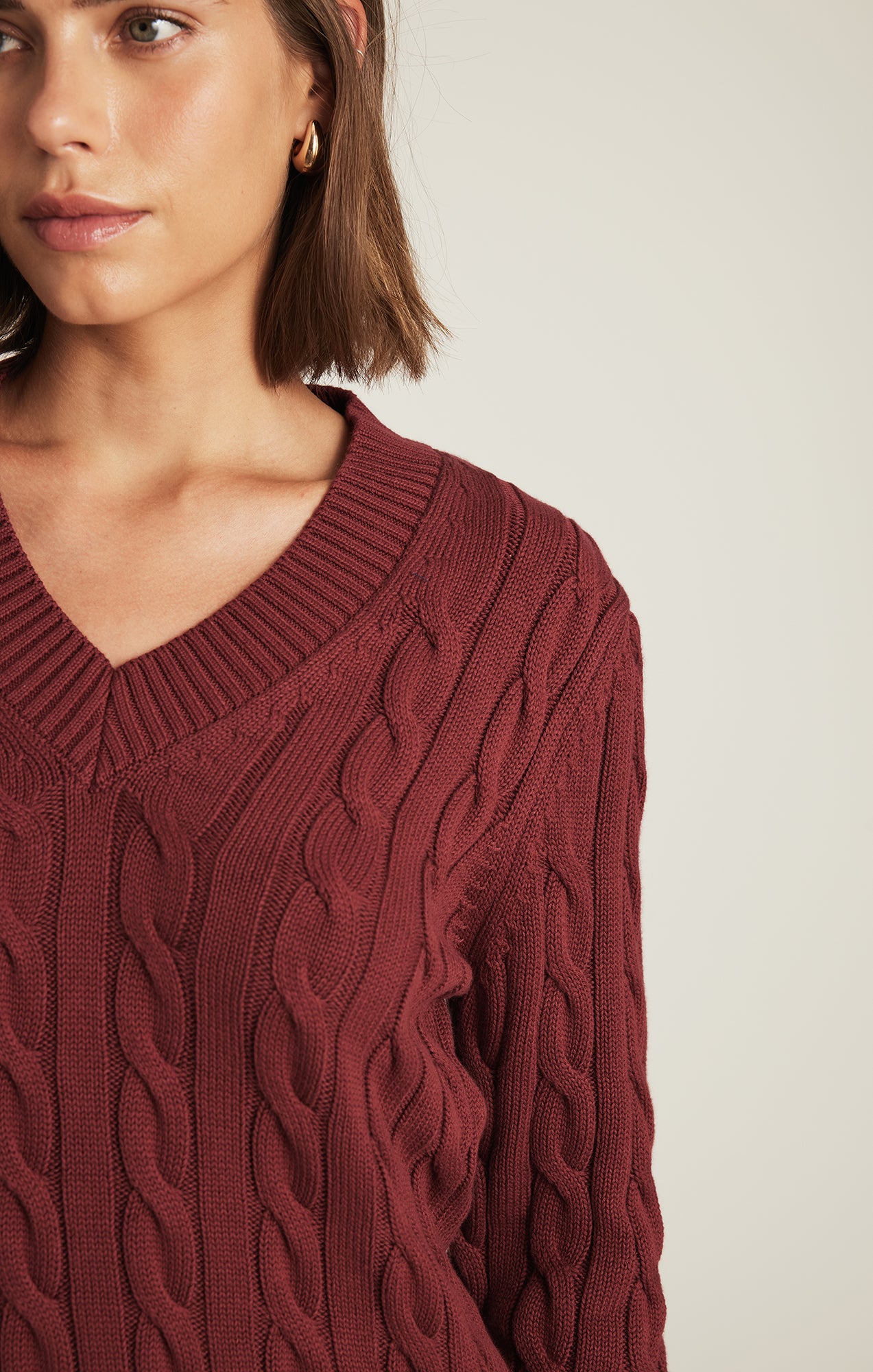CABLE-KNIT V-NECK SWEATER IN POMEGRANATE